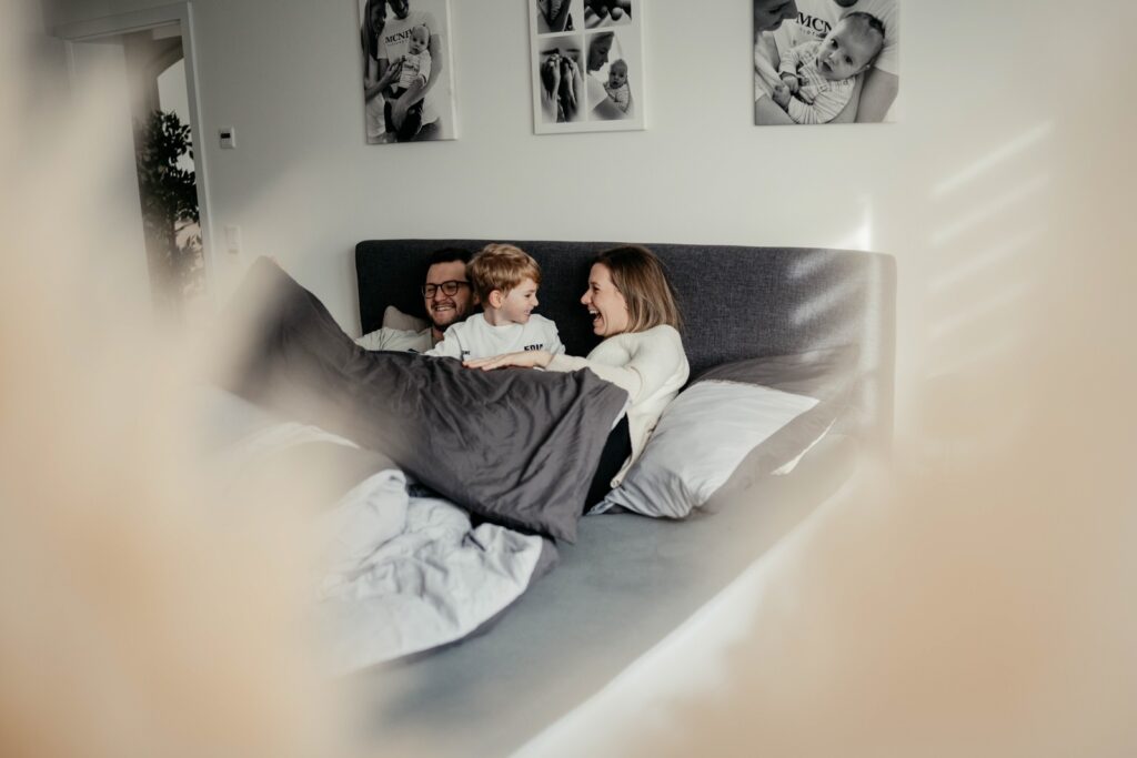 Familie kuschelt gemeinsam im Bett