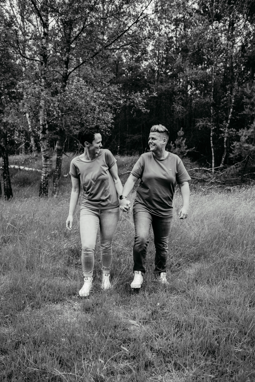 
schwarz weiß Bild. Ein Pärchen, das über eine Wiese läuft und lachend anschaut.