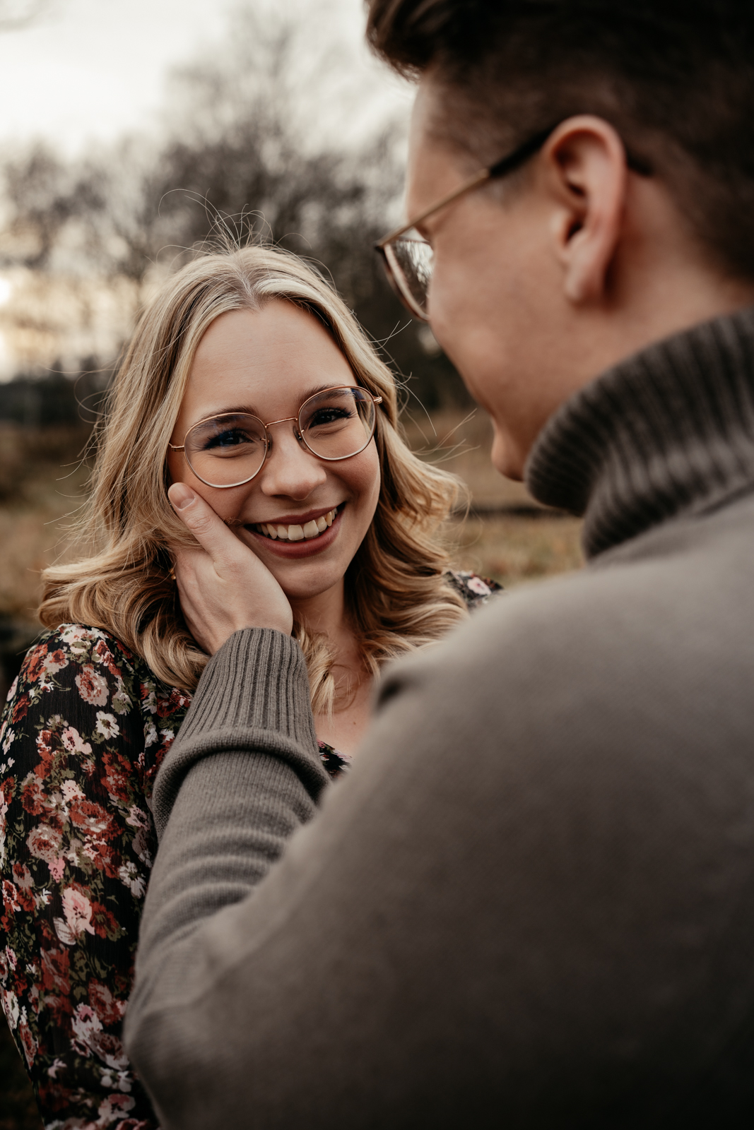  Ein Bild von einem Pärchen. Der Mann hält seine Hand an die Wange seiner Frau. Die Frau schaut in die Kamera und lächelt.